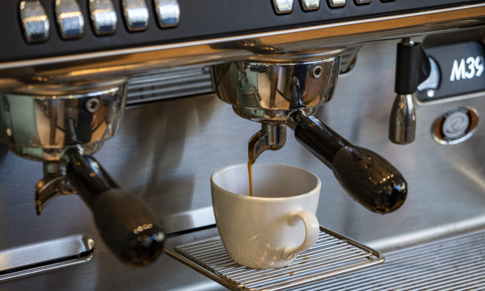 Ein Kaffee wird mit einer Siebträgermaschine zubereitet.