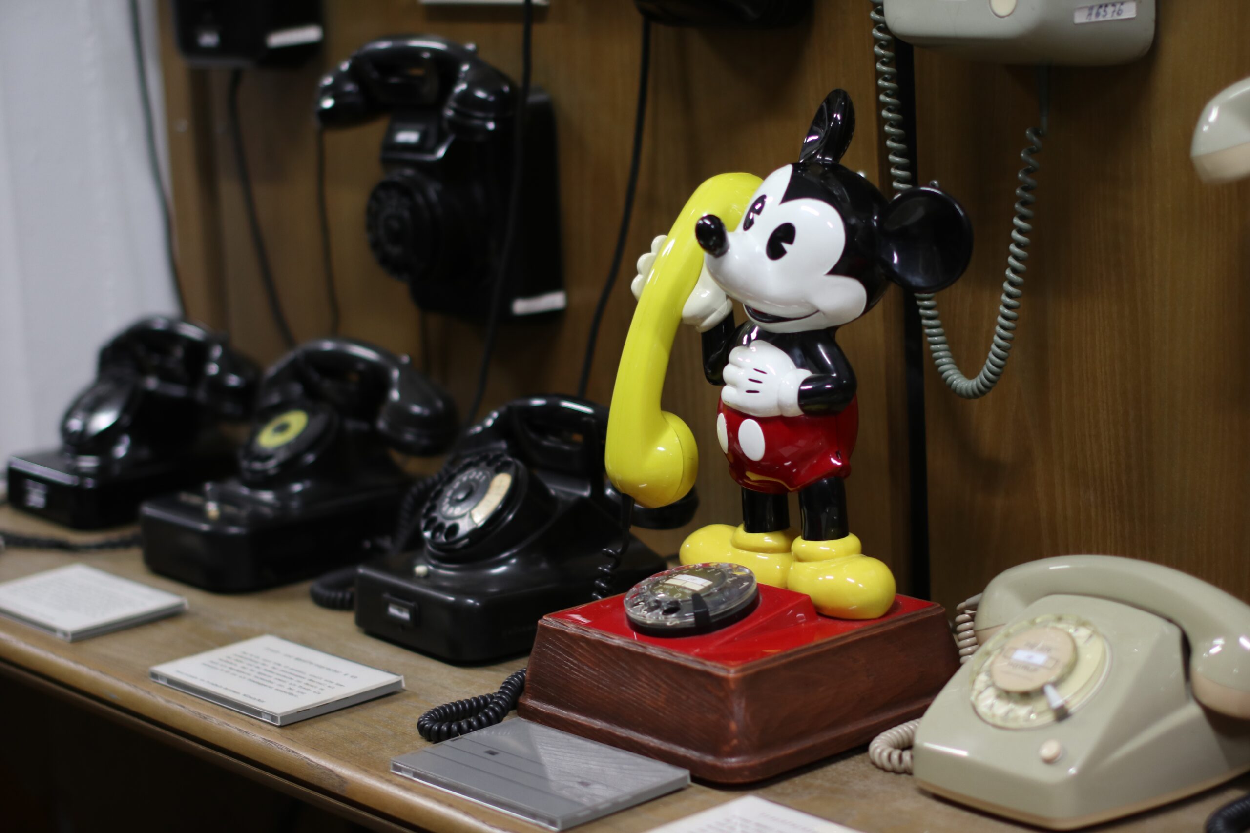 Mickeymoustelefon neben anderen Wählscheibentelefonen