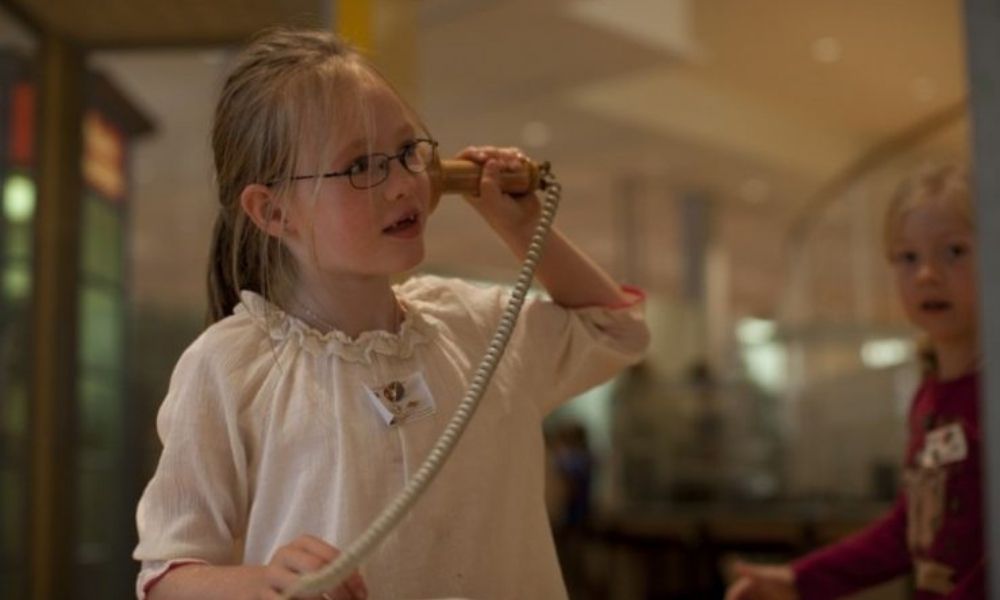 Ein Kind hält sich einen Telefonhörer an das Ohr 