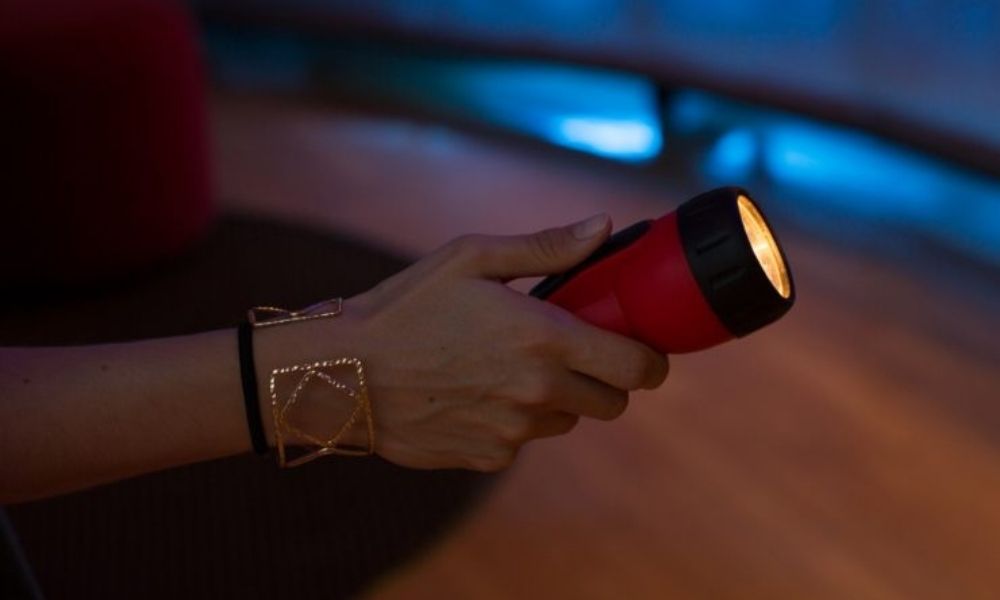 Eine Hand hält eine Taschenlampe im Dunkeln 