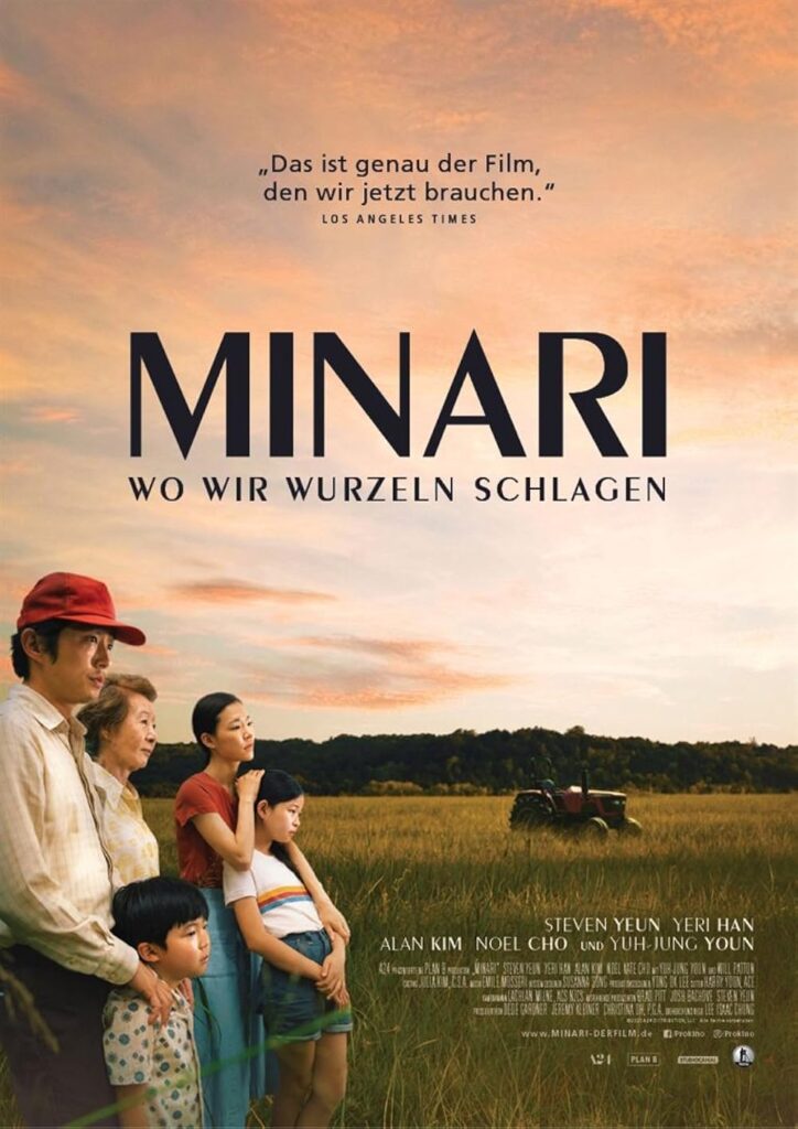 Familie mit zwei Kindern steht in einem Feld vor einem Traktor bei Sonnenuntergang, darüber der Filmtitel 'MINARI WO WIR WURZELN SCHLAGEN'