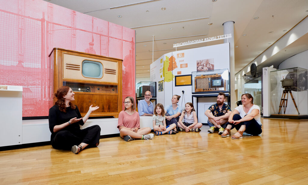 Eine Besucher:innengruppe aus Kindern und Erwachsenen im Museum.